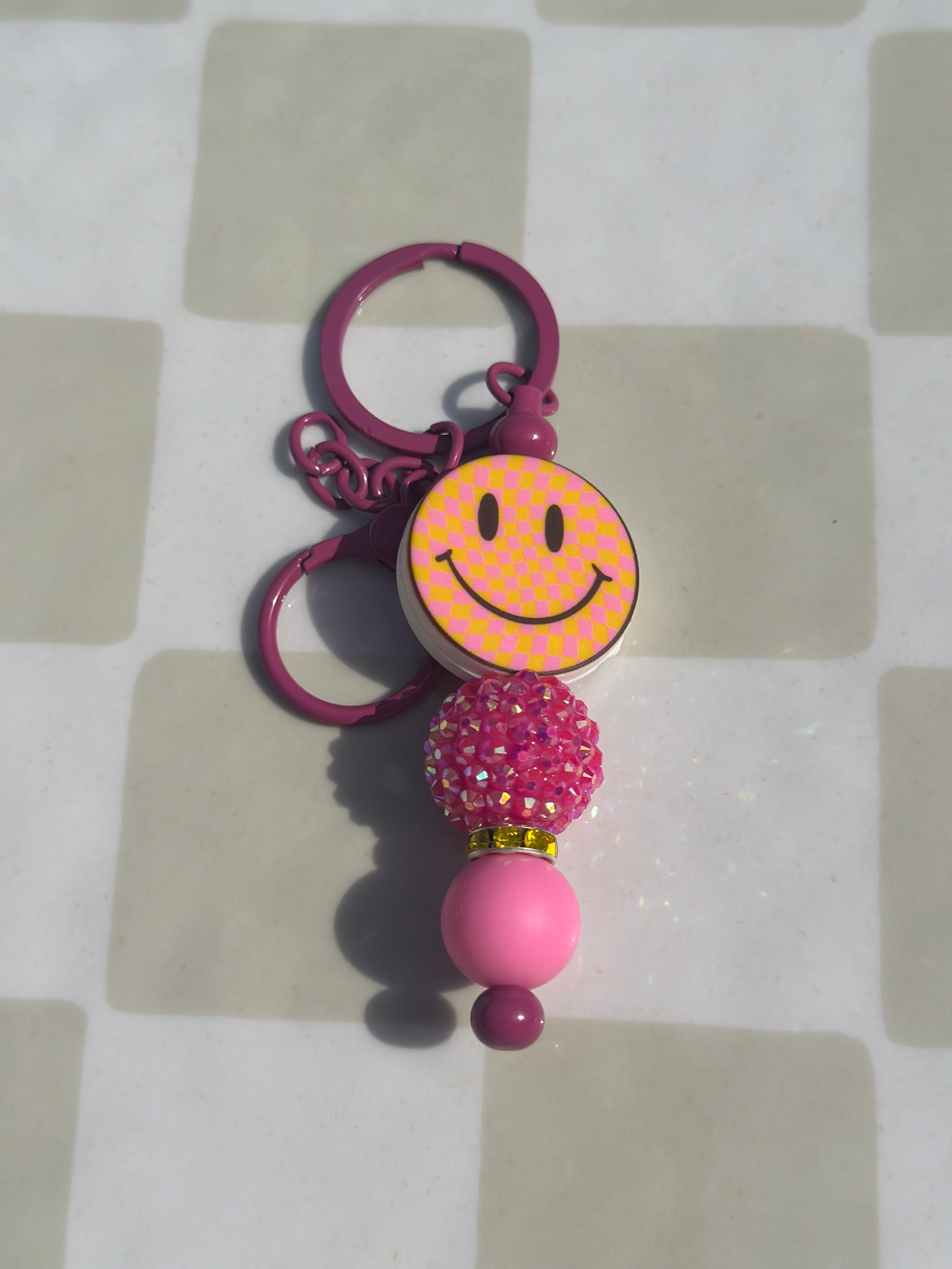 Pink and orange checkered smiley keychain
